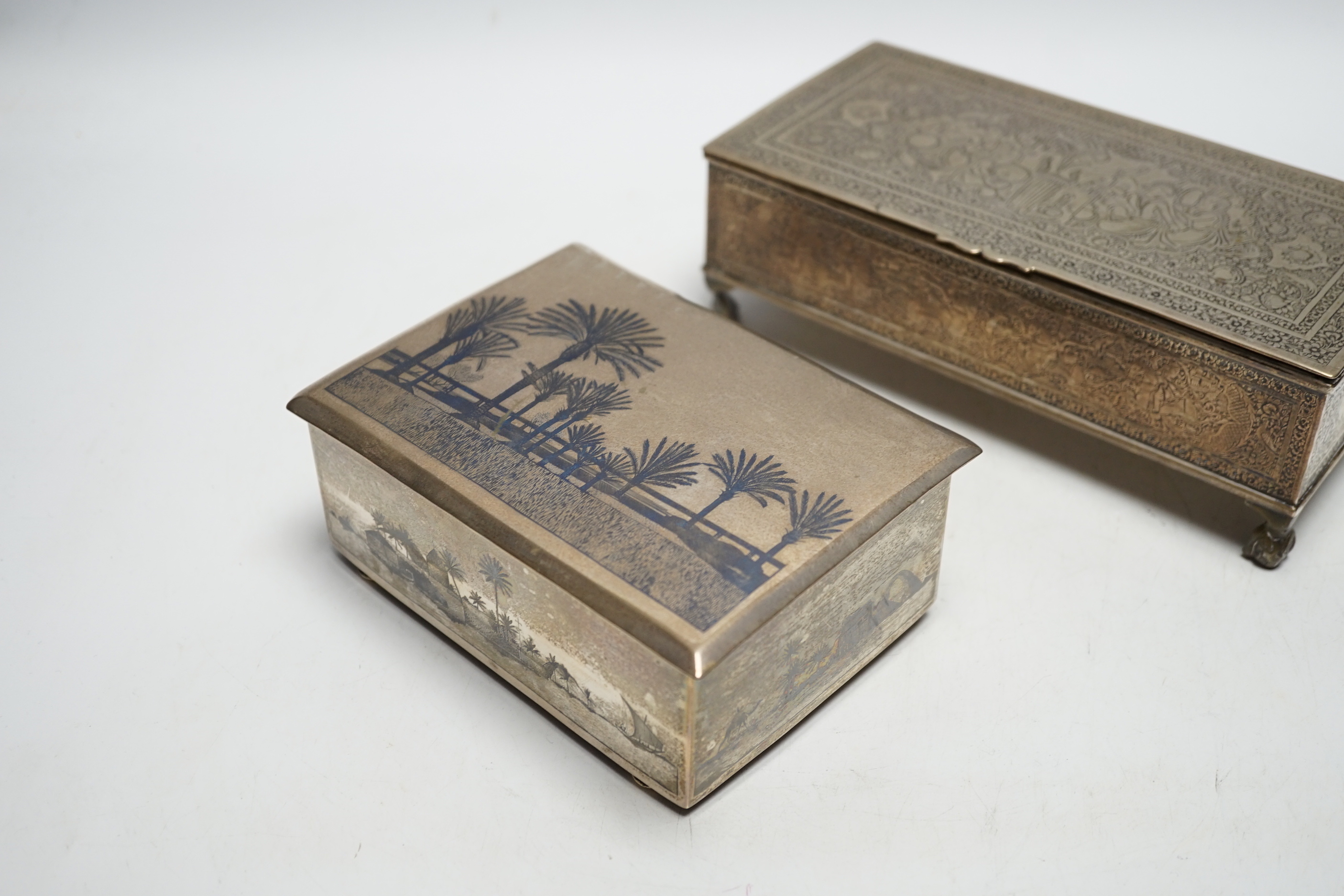 A Persian engraved white metal rectangular cigarette box and a similar white metal and niello cigarette box, largest 20.3cm.